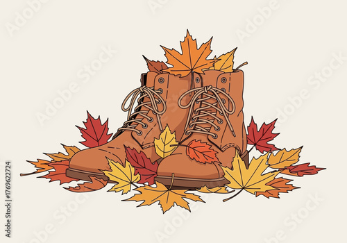 A pair of brown leather hiking boots nestled amongst fallen autumn leaves.