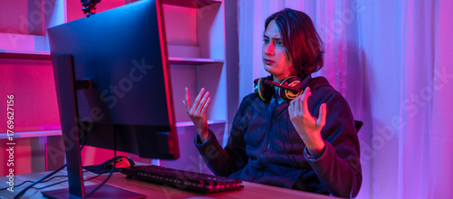 Handsome boy playing E-Sport game or streamer, Defeat or failure, Mistakes of managing a team in the game lead to defeat,  Live show play games, Blue and red lights