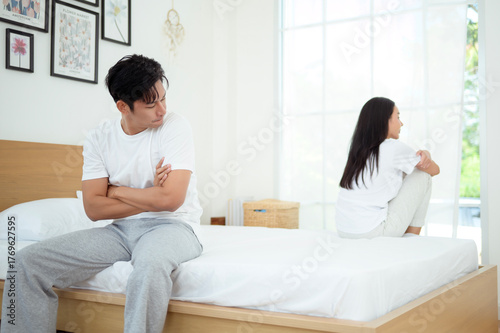 Couple Sitting Apart in Bedroom Experiencing Emotional Distance and Conflict During a Quiet Moment