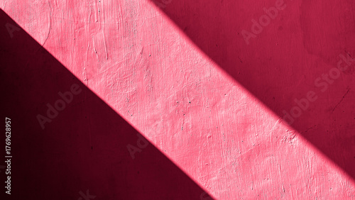 Abstract diagonal light and shadow on a textured red wall, creating minimal composition with natural contrast and geometry