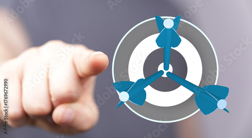 Foto Hand pointing at a dartboard with three darts hitting the center