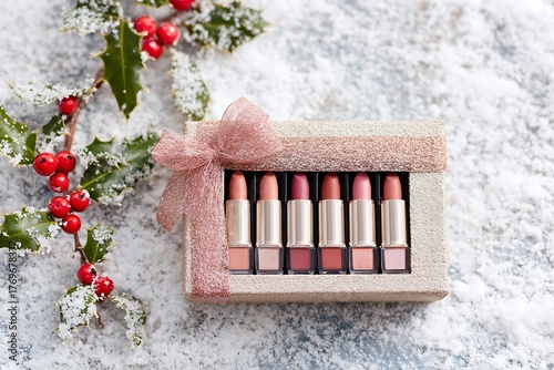 Lipstick set in a glittery box with holly on a snowy white background