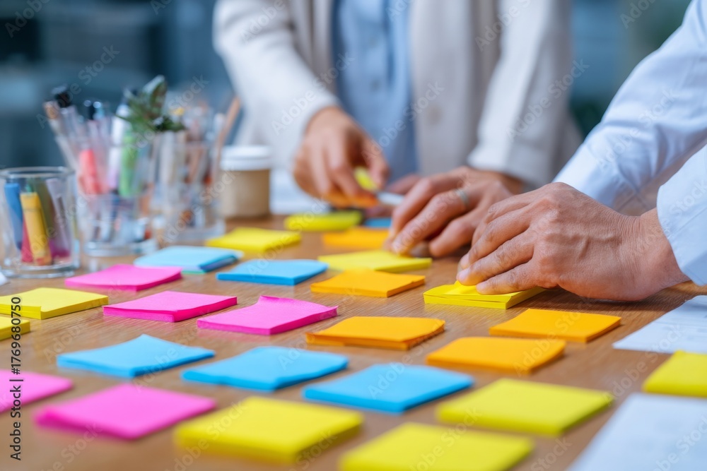 Fototapeta premium Brainstorming session with colorful sticky notes, collaborative planning and ideas on wood table for business strategy