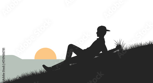 Silhouette Of A Person At Sunset Resting Upon A Grassy Hillside In Peace
