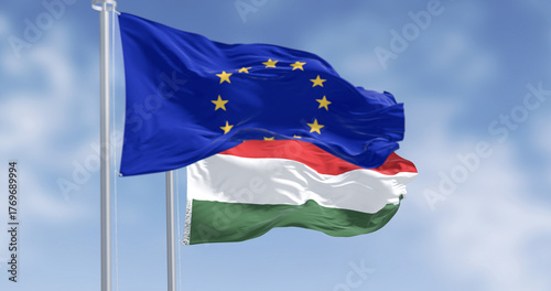 Flags of Hungary and the European Union fluttering together on a clear day