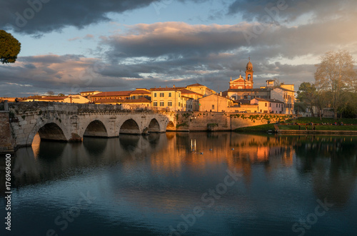 Rimini, italian travel destination. Tiberio bridge, roman architecture. Historic center at sunset.