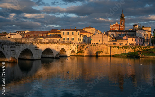 Rimini, italian travel destination. Tiberio bridge, roman architecture. Historic center at sunset.