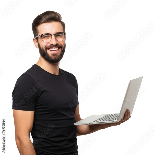 A smiling man with glasses and a beard wearing a black t shirt holds a laptop computer isolated on transparent background