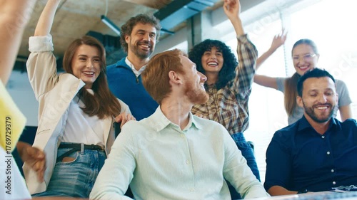 Group of coworkers joining hands in teamwork gesture at workplace. Men and women smiling supporting each other celebrating unity and success together in office environment full of enthusiasm and trust