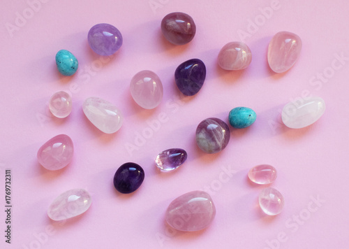 Beautiful natural stones amethysts and rose quartz on pink background. Healing crystals. Predictions and magic.