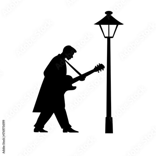 Silhouette of a guitarist playing next to a street lamp