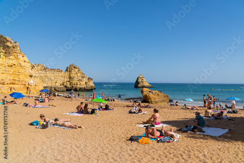 Camilo Beach  (Praia do Camilo) people were sunbathing on the beach and swimming in the ocean. Ponta da Piedade near Lagos in Algarve, Portugal. 