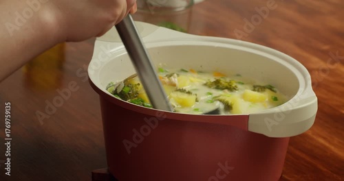 Broccoli soup. Broccoli soup blended, vegetarian soup. Pouring vegetable soup with broccoli into a plate, top view.