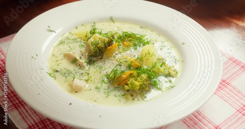Broccoli soup. Broccoli soup blended, vegetarian soup. Pouring vegetable soup with broccoli into a plate, top view.