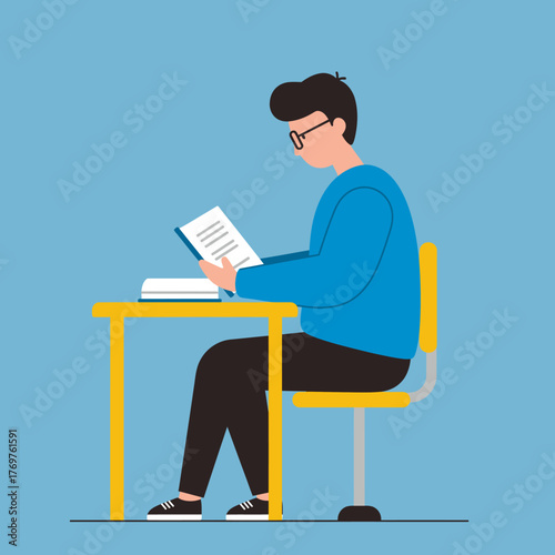 Focused Young Man Reading a Book and Studying at a Desk with a Yellow Chair on a Light Blue Background.