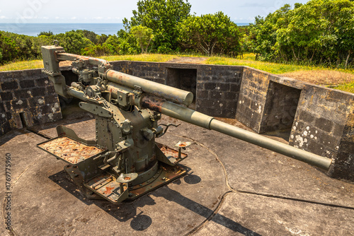 A vintage British 9.4 cm fixed anti-aircraft gun from 1940, located in a coastal fort on Terceira Island, Azores, Portugal. This preserved World War II artillery piece was part of the island’s militar