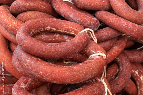 Traditional dried beef sausages displayed in a market.