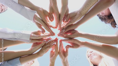 An inspiring display of unity with a variety of diverse hands reaching together in a beautiful circular formation