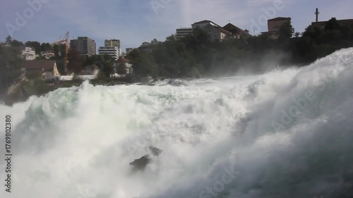 The majestic Rhine Falls, Europe's largest waterfall, with its powerful flow and a rainbow visible through the spray, near the towns of Neuhausen am Rheinfall and Laufen-Uhwiesen