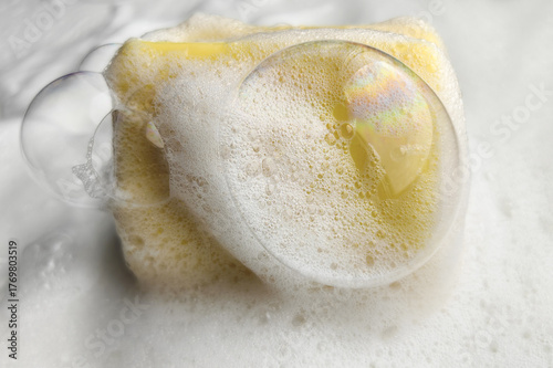 A refreshing cleanliness concept with yellow soap and bubbles in the lather