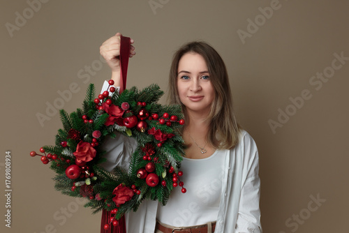 Smiling woman holding a festive Christmas wreath
