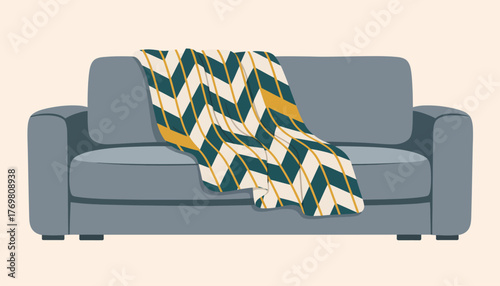 A chevronpatterned throw blanket knitted with yarn in contrasting colors draped over a sofa.