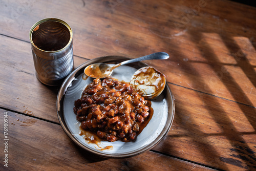Foto A can of chilly and a plate with chilly beans on it ready to be devoured