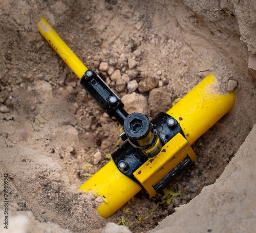 A valve and line shut-off connector located on an underground pipeline. This type of yellow equipment is typically used at control points on natural gas, water, or other pressurized lines.
