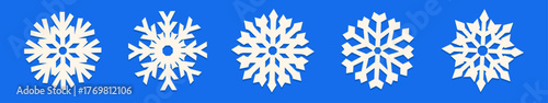 Collection of simple white paper cut out snowflakes on a bright blue background. Festive winter illustration for Christmas projects, holiday wrapping, seasonal prints, and greeting card designs.