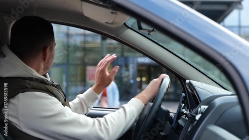 Male sitting in car waiting for daughter looking in window. Rear of male sit in vehicle waits for his kid from school. Man pick up his daughter. Teenage girl running crossing the street