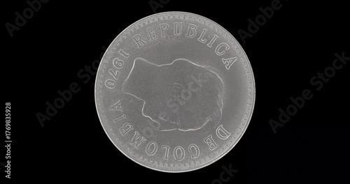 Obverse of Colombia coin 20 centavos 1970, isolated in black background. Loopable animation in 4k resolution video
