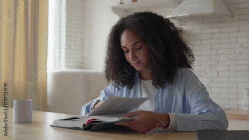 Young Woman Reading Book At Cozy Kitchen Table On Quiet Morning