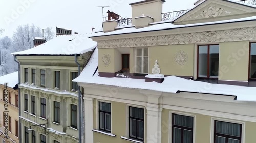 This enchanting video showcases a picturesque winter scene, featuring charming buildings blanketed in fresh snow. The rooftops glisten under a soft winter light, creating a serene atmosphere. Viewers 