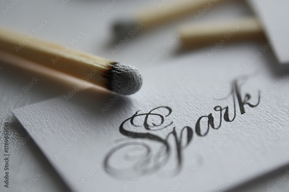Fototapeta premium Close-up of matches arranged around a card featuring the elegant word 'Spark', highlighting creativity