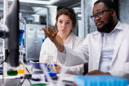 Fotografie Diagnostic laboratory manager showing intern genetic markers associated with disease risk on PC