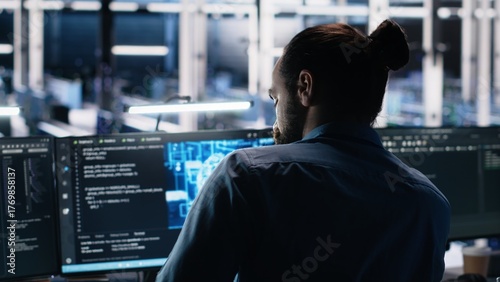 Data center computer scientist using PC to monitor neural network using AI LLM. IT expert at work using artificial intelligence to oversee servers powering machine learning, camera A