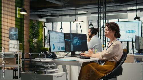 Office administrator checking monthly reports with AI analytics platform, employing neural networks algorithms and automation for efficiency. IT company representative at work.