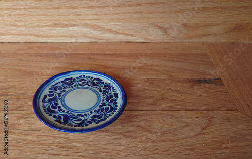 small handpainted Talavera saucer on a wooden shelp
