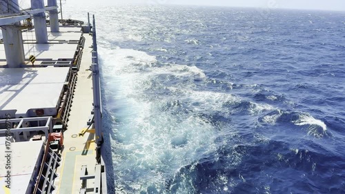 Cargo ship sailing in ocean with strong wind and waves crashing against hull — dynamic maritime scene showing the power of the sea and the resilience of ocean-going vessels in fresh wind conditions 3