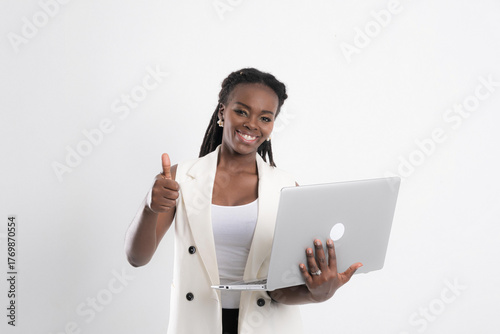 Portrait African black woman with dreadlock in white vest smile confidently hold laptop and giving a thumb up at studio shot on white background.