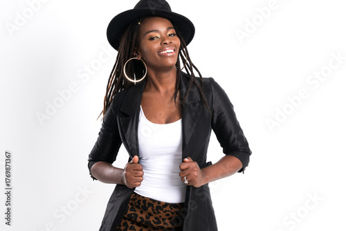 Portrait African American woman with dreadlock and fedora hat, expressing pure joy and confidence with a wide radiant smile against studio shot on white background.