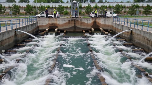 water treatment facility with workers and cascading water channels | industry, environment, technology, infrastructure, manufacturing theme