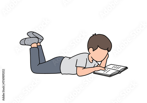 A young boy in casual clothes lying down and reading a book.