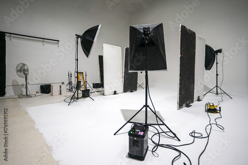 Professional black and white photo studio with lighting equipment and camera setup