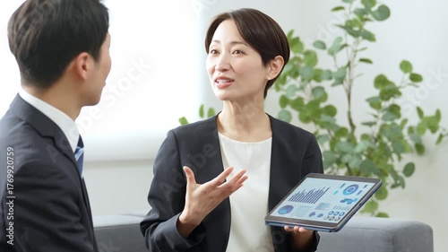 タブレットを使ってミーティングをするビジネスパーソン