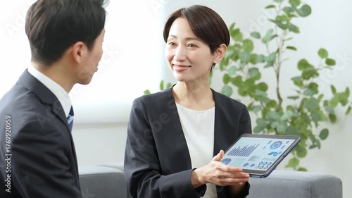 タブレットを使ってミーティングをするビジネスパーソン