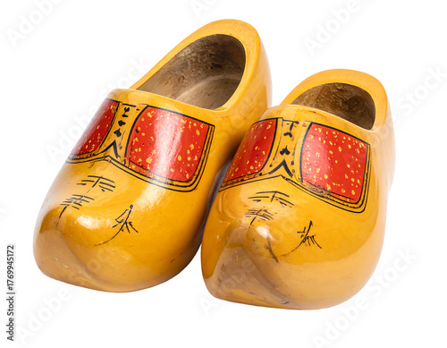 Yellow wooden clogs with red and black decorative elements resting on a solid black background