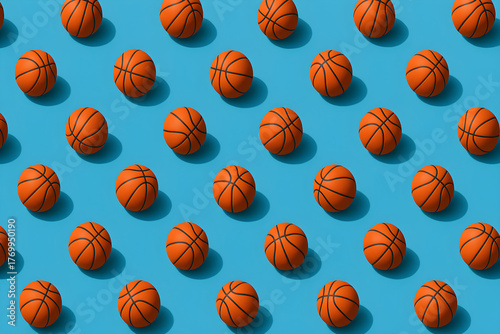 Repeating pattern of orange basketballs with black lines on a light blue background with shadows cast