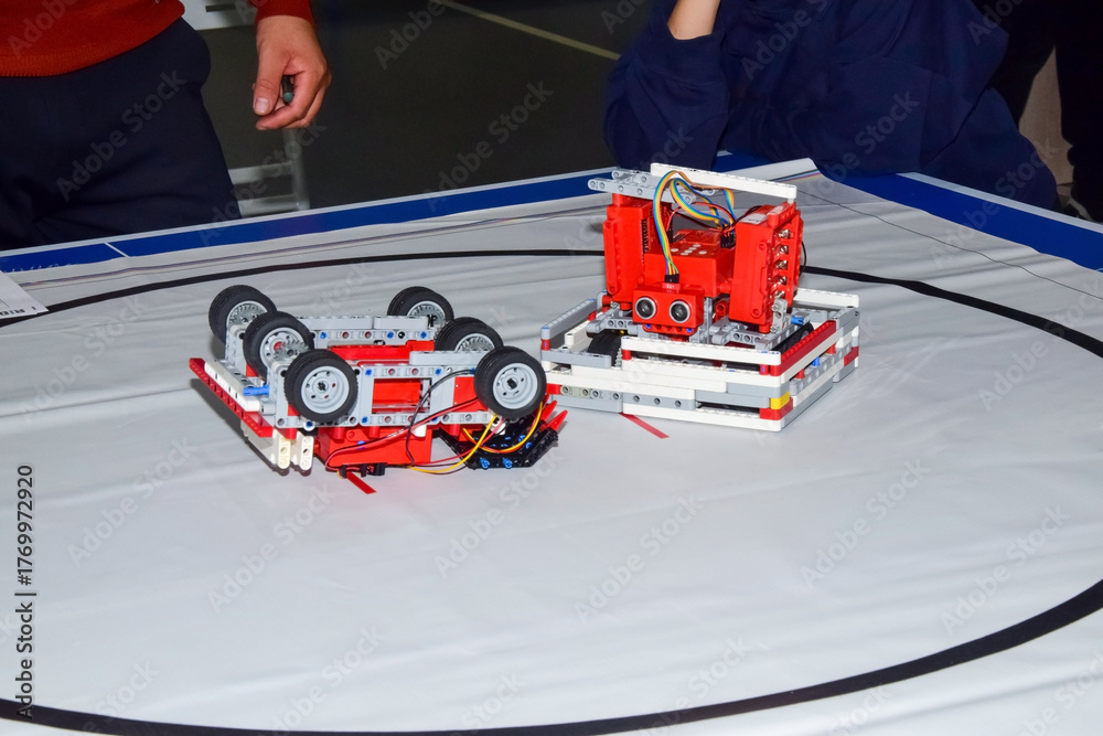 Fototapeta premium Two red robots in a robot sumo competition, victory
