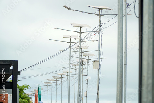 Row of solar powered street lights against a cloudy sky.